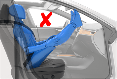 Person sitting in car seat incorrectly with feet on the dash