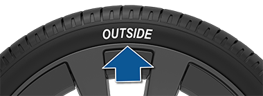 Šipka ukazující na slovo „Outside“ na boku pneumatiky