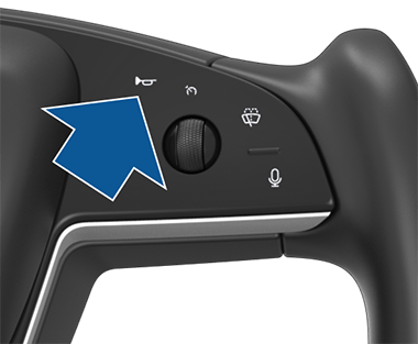 Right side of the steering wheel with an arrow pointing to the top leftmost button.