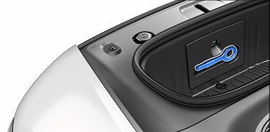 Freccia rivolta verso l'occhiello di traino del vano bagagli anteriore.