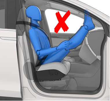Person sitting in car seat incorrectly with feet on the dash