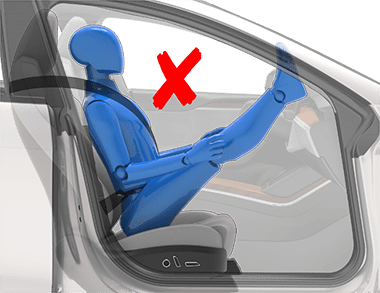 Person sitting in car seat incorrectly with feet on the dash