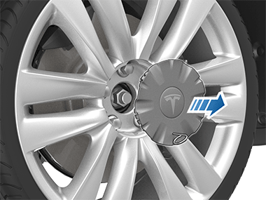 Pulling lug nut tool outwards to remove lug nut cover