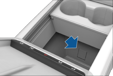 Center console with arm rest lifted, revealing power outlet in the compartment