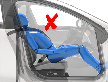 Person sitting in a car seat incorrectly with the backrest in a laying down position