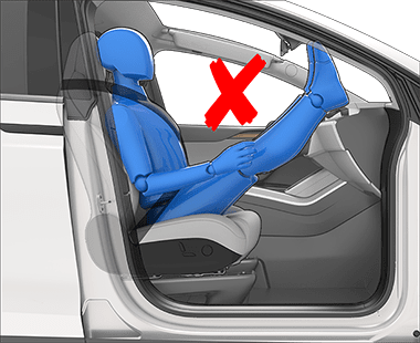 Osoba nesprávně sedící na sedadle s nohama na palubní desce