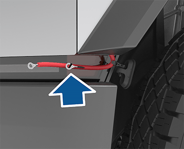 Parte delantera del vehículo con una flecha que muestra los terminales positivo y negativo conectados a la cubierta del terminal de acceso del maletero delantero