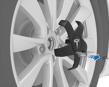 Pulling lug nut tool outwards to pull lug nut cover off