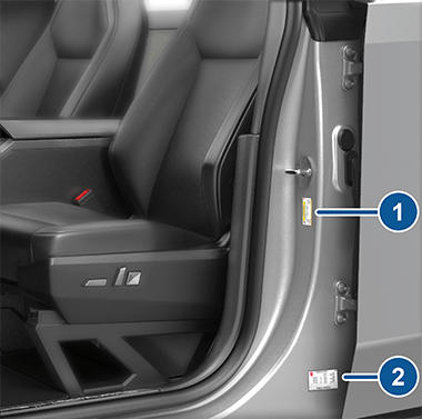 Two labels on the driver's center door pillar indicating how much weight the vehicle can carry